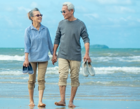 pareja mayor caminando por la playa